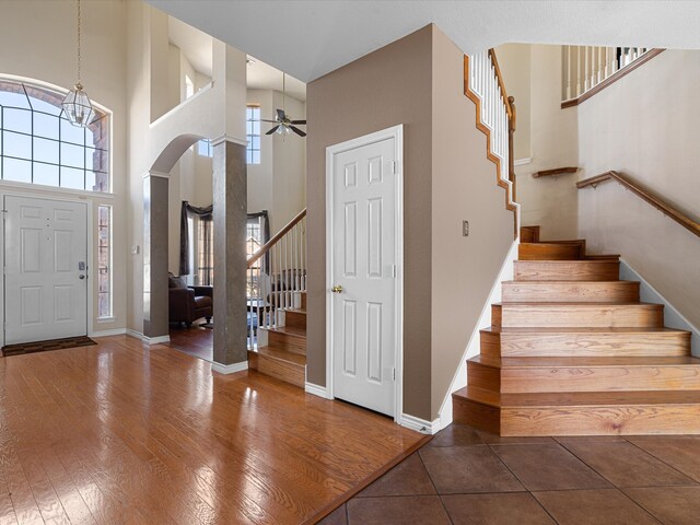 entrance foyer with hardwood / wood-style flooring, baseboards, a high ceiling, and stairway