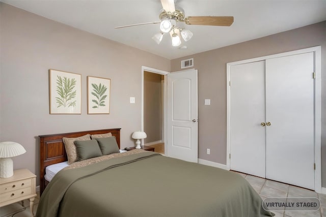 bedroom with ceiling fan, light tile patterned flooring, visible vents, baseboards, and a closet