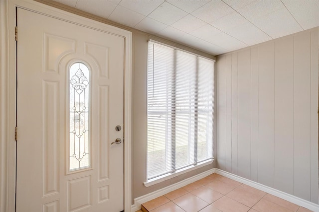 foyer entrance featuring light tile patterned flooring and baseboards