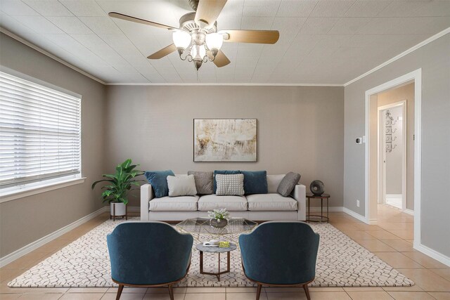 living room featuring ceiling fan, crown molding, baseboards, and light tile patterned floors