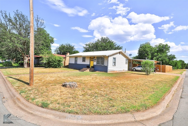 ranch-style house featuring a carport, metal roof, and a front lawn