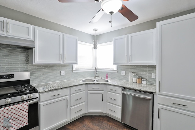 kitchen featuring stainless steel appliances, backsplash, white cabinets, a sink, and under cabinet range hood