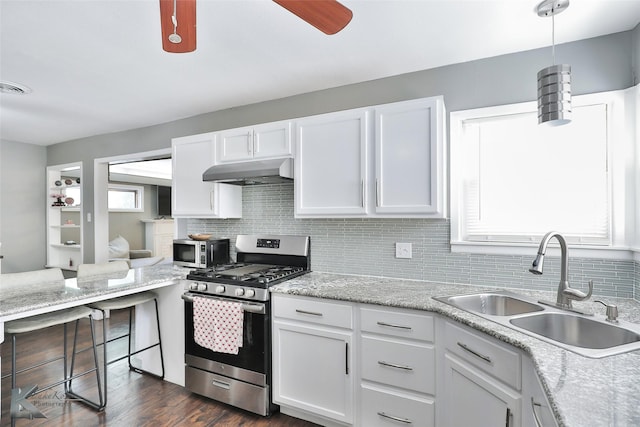 kitchen featuring under cabinet range hood, white cabinetry, stainless steel appliances, and a sink