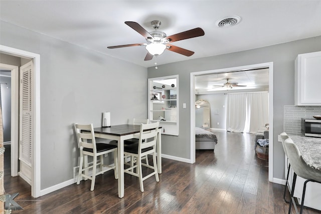 dining area with ceiling fan, baseboards, visible vents, and dark wood finished floors