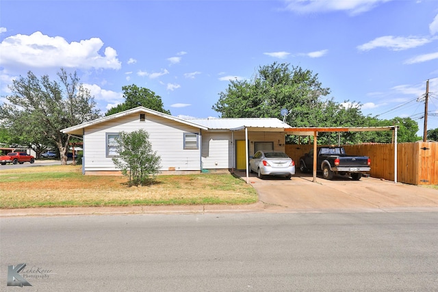 view of front of property with a carport, fence, driveway, and a front lawn