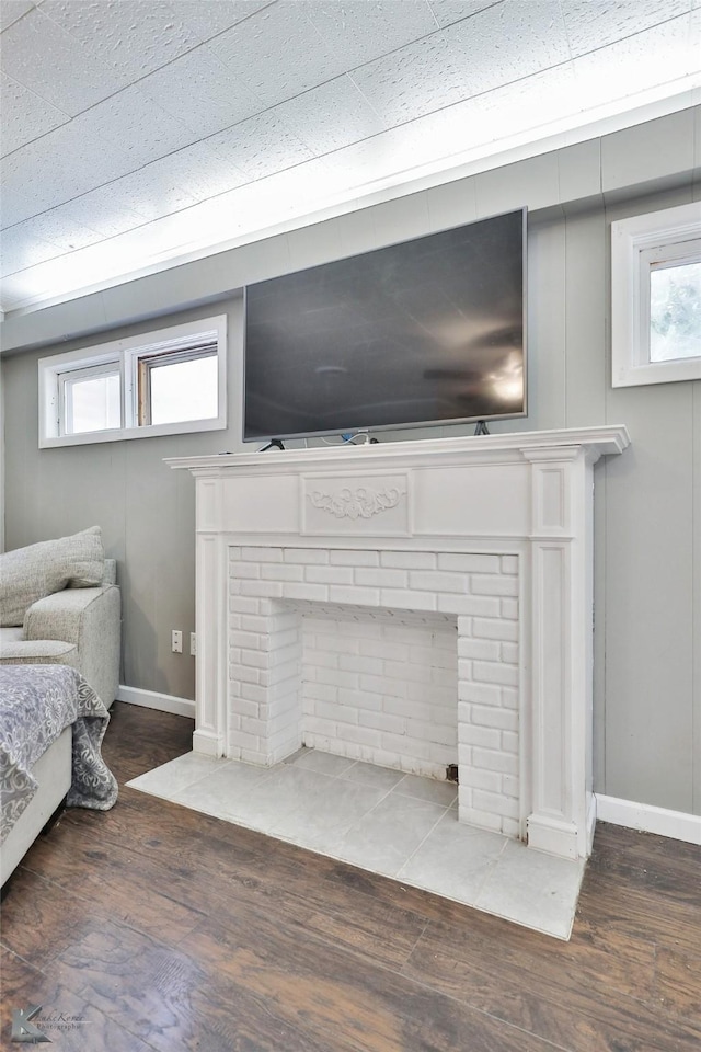 details featuring a fireplace, baseboards, and wood finished floors