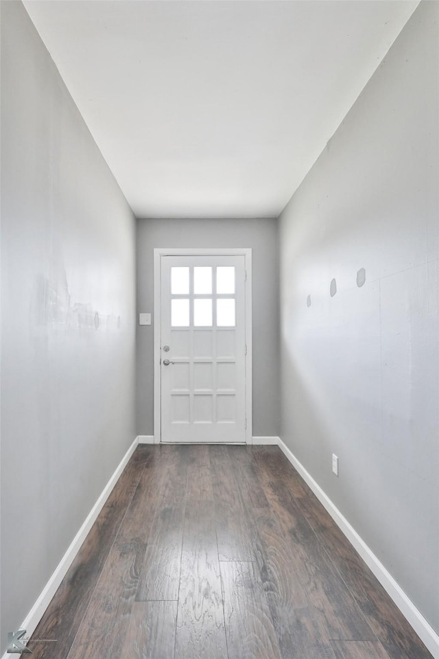 doorway to outside featuring baseboards and hardwood / wood-style floors