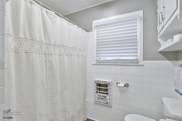 bathroom featuring a shower with curtain, heating unit, tile walls, and toilet