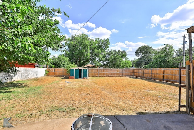 view of yard with an outbuilding, a storage shed, and a fenced backyard