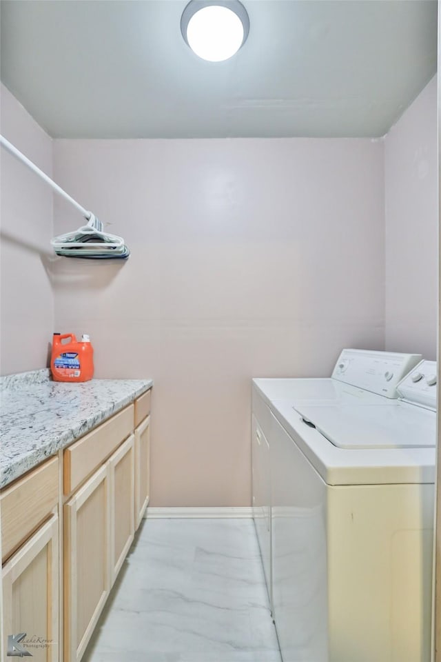 washroom with cabinet space, marble finish floor, and washing machine and clothes dryer