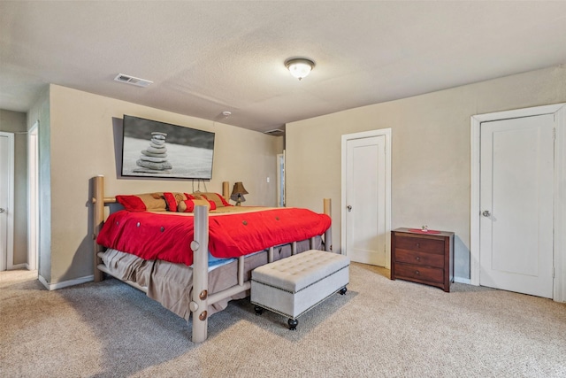 bedroom with baseboards, a textured ceiling, visible vents, and carpet flooring