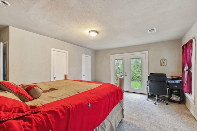 bedroom with access to exterior, carpet floors, french doors, visible vents, and a textured ceiling