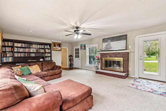 living room with a ceiling fan, carpet, and a brick fireplace