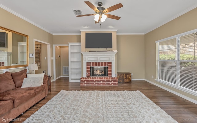 living area featuring dark wood-style floors, a brick fireplace, visible vents, and baseboards