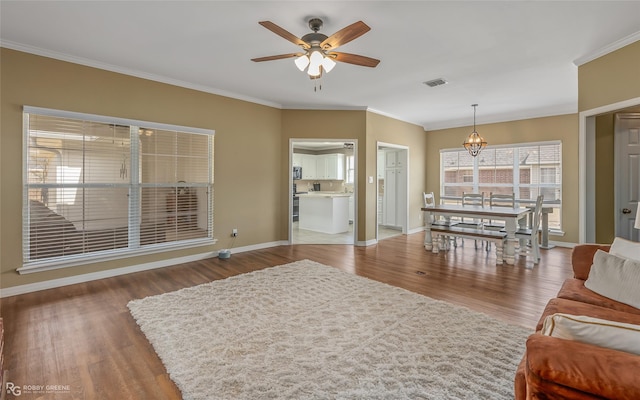 living room featuring ornamental molding, visible vents, and wood finished floors