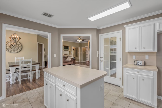 kitchen featuring light tile patterned floors, light countertops, visible vents, and white cabinetry