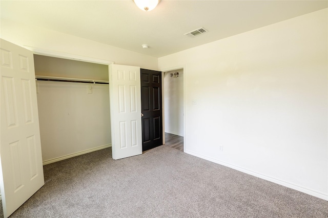 unfurnished bedroom with baseboards, visible vents, a closet, and carpet