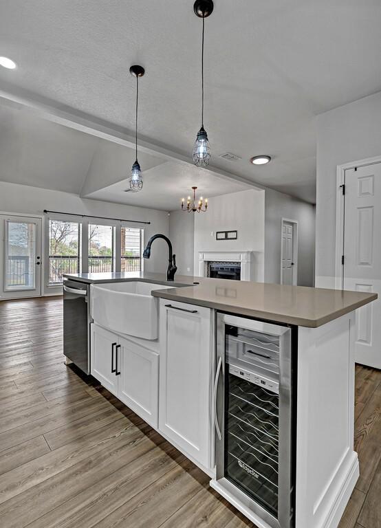 kitchen with beverage cooler, a sink, dishwasher, and open floor plan