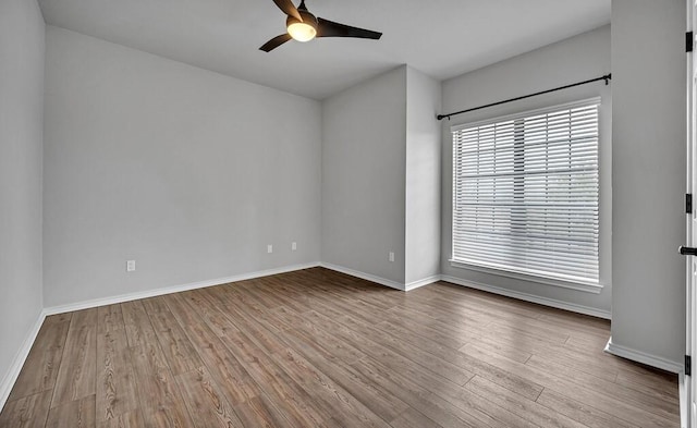 empty room with baseboards, a ceiling fan, and wood finished floors