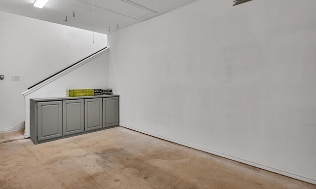 interior space featuring attic access and unfinished concrete floors