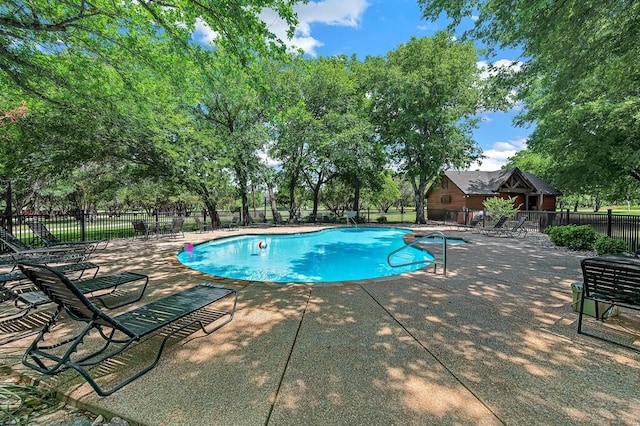 community pool featuring fence and a patio