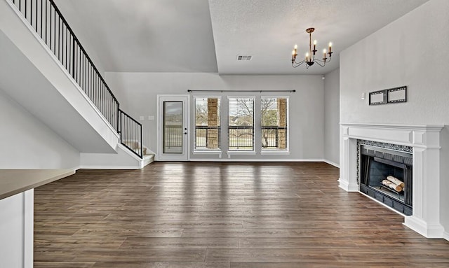 unfurnished living room with stairs, dark wood-type flooring, a fireplace, and visible vents