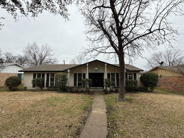 view of front facade with a front lawn and brick siding