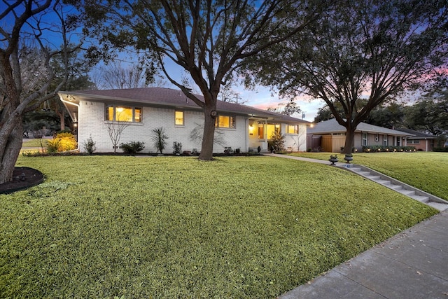 ranch-style house with brick siding and a front yard