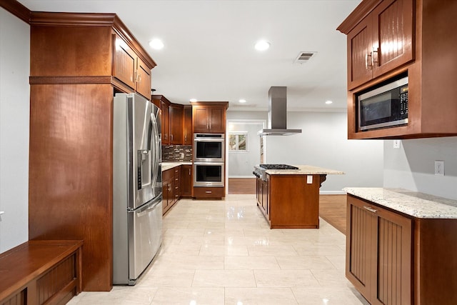 kitchen featuring visible vents, decorative backsplash, light stone countertops, range hood, and stainless steel appliances