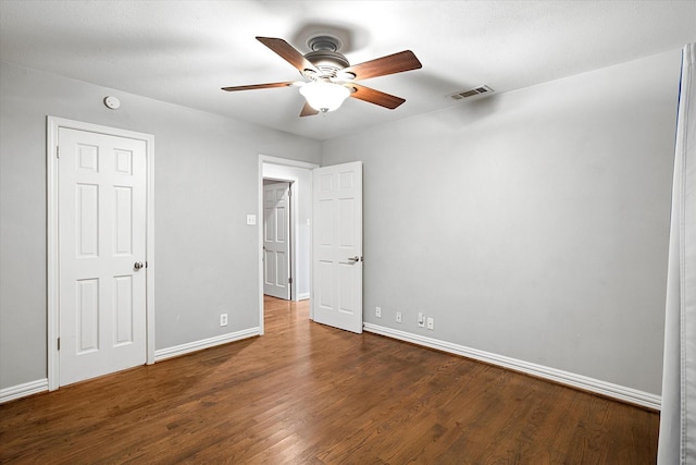 unfurnished bedroom featuring ceiling fan, wood finished floors, visible vents, and baseboards