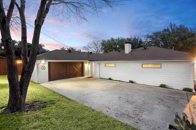 single story home featuring brick siding, a chimney, concrete driveway, fence, and a garage