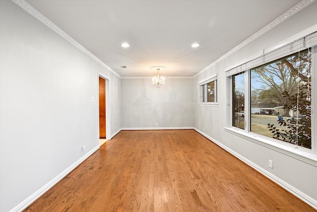 empty room with crown molding, recessed lighting, an inviting chandelier, wood finished floors, and baseboards