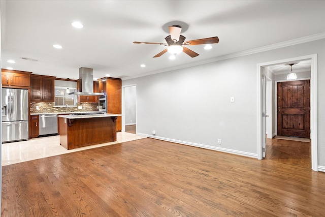 kitchen featuring stainless steel appliances, light countertops, visible vents, decorative backsplash, and island range hood