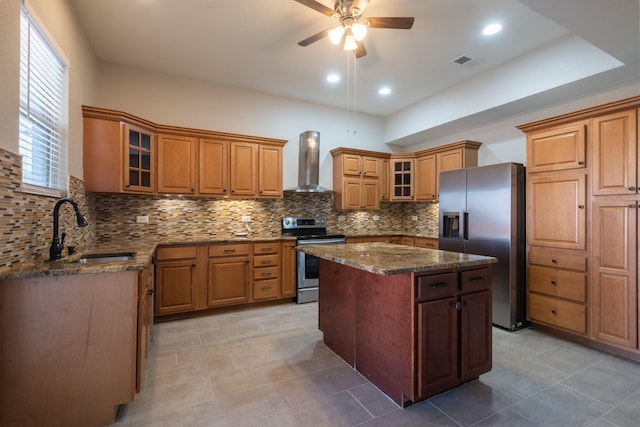 kitchen featuring a sink, visible vents, appliances with stainless steel finishes, wall chimney exhaust hood, and brown cabinetry