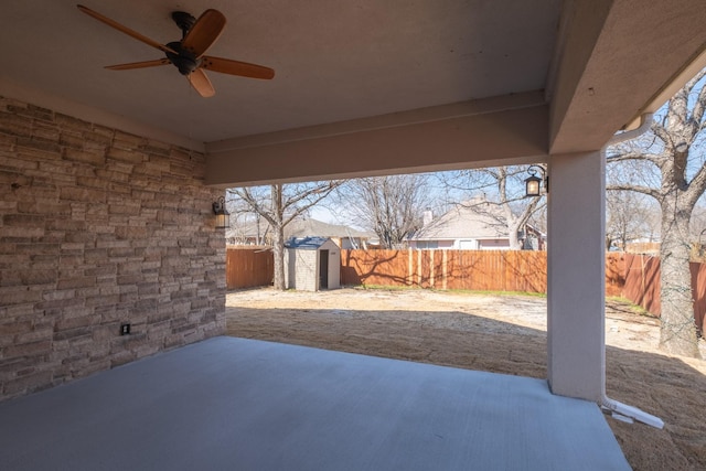 view of patio / terrace featuring a ceiling fan, an outbuilding, a fenced backyard, and a shed