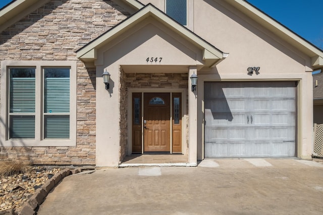 entrance to property with a garage, stone siding, driveway, and stucco siding