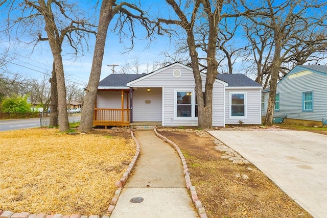 view of front of property with a shingled roof and a front lawn