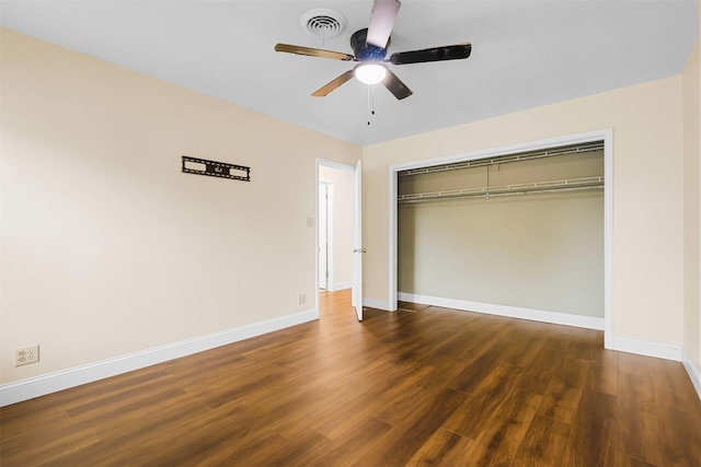 unfurnished bedroom with a closet, visible vents, baseboards, and wood finished floors