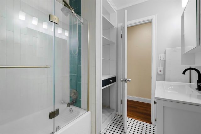 full bathroom featuring bath / shower combo with glass door, wood finished floors, vanity, baseboards, and ornamental molding