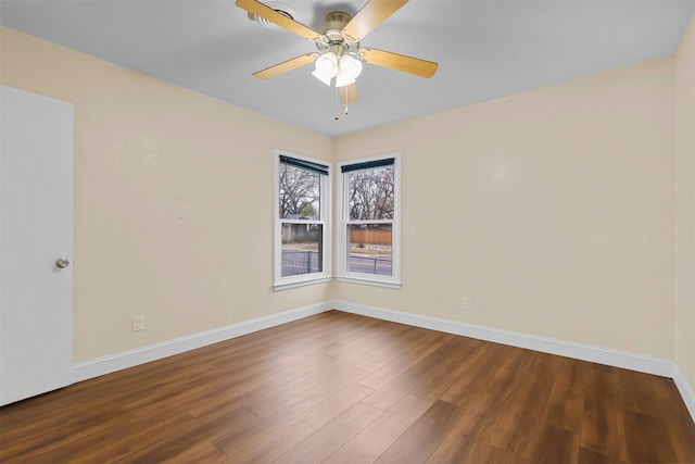 unfurnished room with ceiling fan, wood finished floors, and baseboards