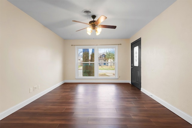 empty room featuring baseboards, visible vents, ceiling fan, and dark wood-type flooring