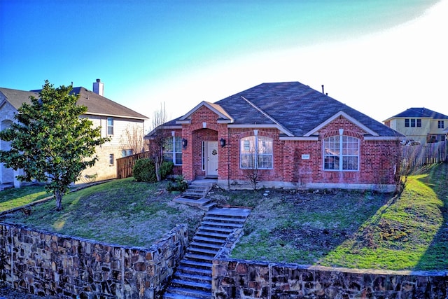 view of front of house with brick siding and fence