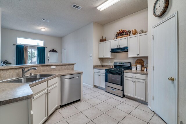 kitchen with light tile patterned floors, visible vents, a sink, under cabinet range hood, and appliances with stainless steel finishes