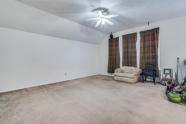 unfurnished room with a ceiling fan, lofted ceiling, a textured ceiling, and carpet flooring