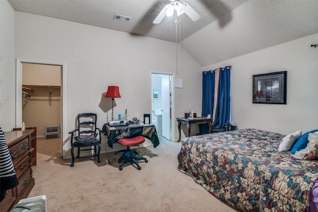 bedroom with carpet, visible vents, lofted ceiling, a spacious closet, and a textured ceiling