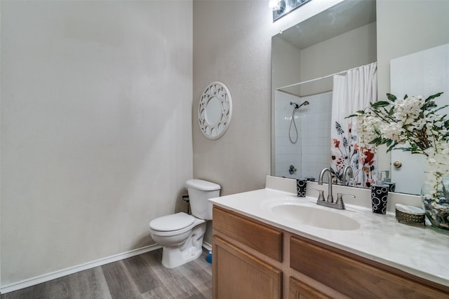 full bathroom with vanity, a shower with curtain, wood finished floors, baseboards, and toilet