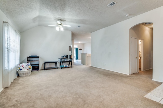 interior space with vaulted ceiling, visible vents, arched walkways, and ceiling fan