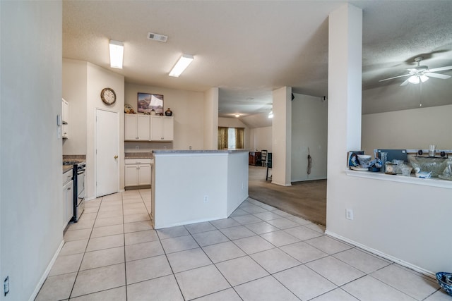 kitchen with visible vents, open floor plan, white cabinets, gas stove, and a ceiling fan