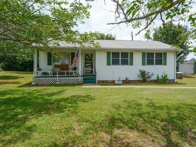 ranch-style home featuring covered porch and a front lawn