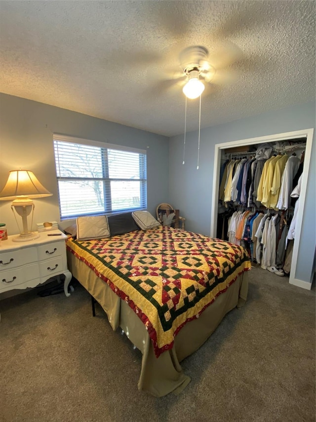 bedroom featuring a textured ceiling, a ceiling fan, dark colored carpet, and a closet